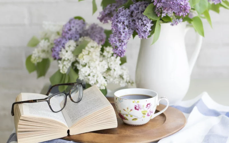 Glasses on a book besides flowers